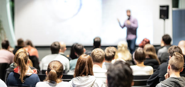 Man giving a presentation in front of a crowd of people